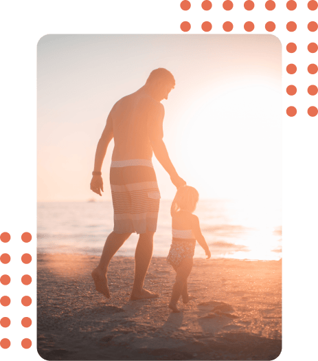 Vater mit Sohne am Strand bei Sonnenuntergang